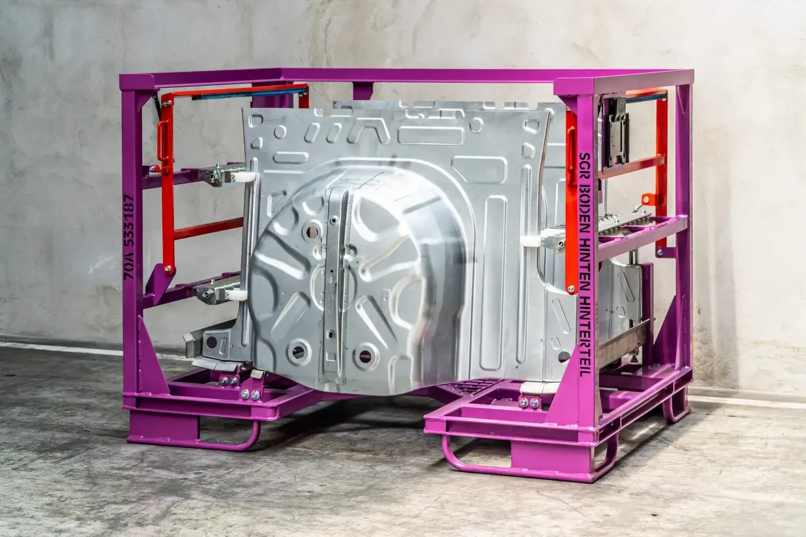 średnich rozmiarów metalowy pojemnik fioletowy pół zautomatyzowany do lini produkcyjnych z elementem karoserii w środku w zakładzie Strumet